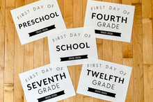 Load image into Gallery viewer, Five signs indicating the 'First Day of School' for different grade levels on a wooden floor.