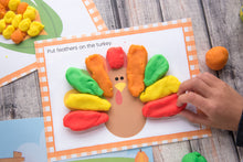 Load image into Gallery viewer, child playing with colorful playdough turkey for thanksgiving - printable mats on wood background
