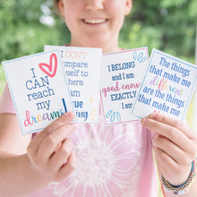 Load image into Gallery viewer, teenager girl holding positive affirmation cards with green forest background