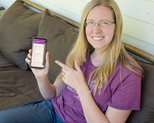 Load image into Gallery viewer, blonde woman wearing glasses in a purple shirt sitting on a brown couch and holding android phone with todoist app featured
