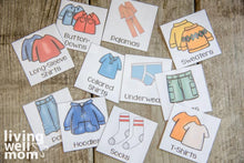 Load image into Gallery viewer, layout of colorful labels with kids clothes on wood background
